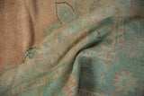 Distressed texture and muted peach, sea foam green patterns on a vintage Oushak carpet fold.