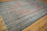 Distressed Oushak carpet's worn pile, revealing dusty blue, pale brick red, and sea foam green.