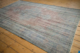 Distressed texture and muted overdyed blue and red tones of the vintage Oushak rug.