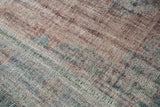 Distressed pile of the Oushak carpet, showing worn knot heads and subtle blue, mauve, green.