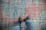 Textured vintage distressed Oushak rug with faded raspberry, pale blue, and seafoam green tones.