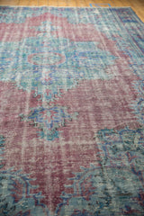 Textured detail of a distressed Vintage Oushak rug, with faded raspberry, sea foam blue, and visible foundation.
