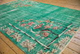 Distressed turquoise green Art Deco carpet corner with red and ivory lotus sprays.