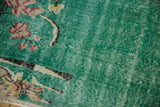 Distressed pale turquoise green blue pile of the Turkish carpet, showing wear to knot heads and floral details.
