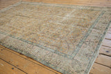 Vintage distressed Sparta rug with faded scrolling vinery, dusty gold tones, and visible wear.
