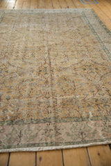 Distressed Sparta carpet detail, pale gold, mauve, green floral vinery, worn texture.