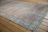 Distressed texture of vintage Sparta carpet, terracotta, ivory, and blue floral field.