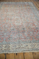 Distressed Sparta rug with terracotta floral vinery, visible knot heads, and cartouche border.