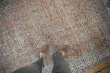 Distressed vintage Sparta carpet featuring terracotta and blue floral motifs with visible wear.