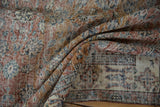 Distressed Sparta carpet pile with terracotta floral motifs and stylized border patterns.