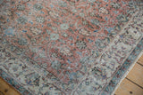 Distressed Sparta carpet field shows apricot scrolling vinery and ivory arabesque border.