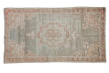 Vintage distressed Oushak rug featuring faded silver and pale terracotta medallion design.