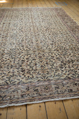 Distressed Vintage Sparta carpet detail of scrolling vinery, low pile, faint foundation, and fringe.