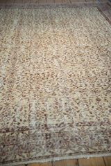 Textured distressed pile showcasing ivory and bronze scrolling vinery and buds.