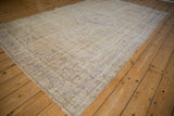 Distressed vintage Oushak carpet, muted ivory and beige with faded pale blue patterns.