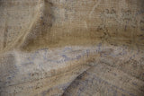 Distressed vintage Oushak rug pile with worn beige tones and faint blue motifs.