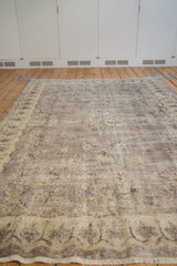 Distressed vintage Sparta carpet, revealing muted silver, ivory, floral, and scalloped patterns.