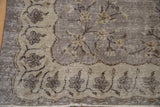 Scalloped ivory border detail on vintage distressed Sparta rug with muted floral pattern.