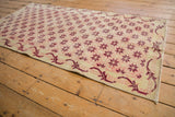 Distressed pile showing faint foundation and ivory, dusty rose floral starbursts on vintage Sparta runner.