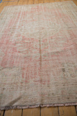 Decorative distressed texture on this vintage Oushak rug featuring faded rose and ivory tones.