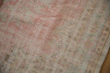 Vintage Oushak carpet's distressed pile, displaying mostly even wear, pale rose, ivory, and seafoam.