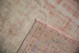 Distressed pile and pale rose fringe of vintage Oushak rug, revealing its hand-knotted foundation.