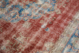 Distressed vintage Sivas rug detail, showing cherry red, sky blue, and ivory foundation.