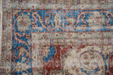 Distressed Sivas carpet detail: worn cherry red, sky blue, ivory motifs, and exposed foundation.
