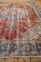 Distressed cherry red and sky blue patterns with worn fringe on vintage Sivas carpet.