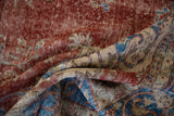 Distressed Sivas rug close-up, revealing worn cherry red pile, sky blue motifs, and visible foundation.