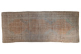Vintage distressed Oushak rug runner with a large, faded medallion in pale sandalwood, silver, and slate.