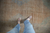 Evenly worn knot heads on a distressed Oushak rug in dusty sandalwood and slate tones.