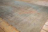 A close-up of the vintage Oushak rug's even wear, showing the distressed, low-pile texture.