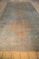 A long view of a distressed vintage Oushak runner, highlighting its even wear and pale sandalwood patina.