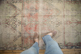 Vintage Distressed Oushak runner, geometric panel design, worn pile reveals brick, saffron, mint tones.