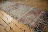Worn texture of a vintage distressed Oushak runner, highlighting geometric plants and muted tones.