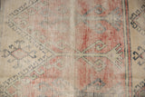 Distressed vintage Oushak runner fragment, brick red, charcoal geometric motifs on worn beige.