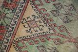 Distressed hand-knotted pile showcasing geometric motifs in brick red, saffron, and mint green.