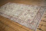 Distressed vintage Sparta runner corner with ivory field, red, navy floral cartouche border.