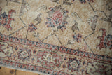 Distressed vintage Sparta runner detail showing ivory, red, and navy floral motifs with visible knot heads.