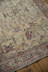 Distressed Sparta rug close-up showing faded beige field, brick red palmettes, cartouche border.