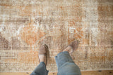 Distressed vintage Oushak rug texture showing worn pile and soft, neutral tones.