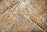 Curled corner of distressed Oushak runner showing hand-knotted foundation, worn pile, and sandy beige colors.