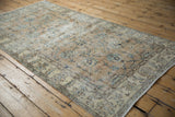 Distressed vintage Sparta runner corner, displaying worn floral palmettes, vinery, and side selvage.