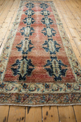 Distressed vintage Sparta rug detail, navy palmettes on abrashed red, Rococo floral border.