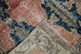 Distressed vintage Turkish Sparta rug pile with foundation visible through worn rust red and navy.