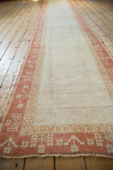Distressed Oushak runner showcasing soft pile, ivory field, and plant motif borders.