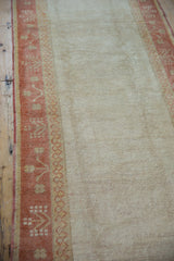 Distressed Oushak runner with high luster ivory pile and sunset orange, pale gold motifs.