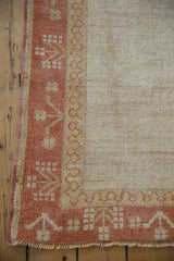 Distressed vintage Oushak runner corner, ivory field, sunset orange pawn and plant motif borders, fringe.