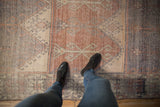 Distressed Oushak runner with repeating panels, muted tones, and worn texture seen underfoot.